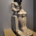21-Dynasty-5,-granite,-Tomb-in-Saqqara,-Official-seated-statue,-Sculpted-in-a-royal-workshop,-Ancient-Egypt,-History-Pharaohs,-Grand-Egyptian-Museum,-wig,-a-wide-necklace,-a-pleated-kilt