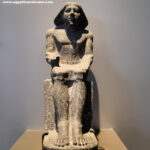 21_1-Dynasty-5,-granite,-Tomb-in-Saqqara,-Official-seated-statue,-Sculpted-in-a-royal-workshop,-Ancient-Egypt,-History-Pharaohs,-Grand-Egyptian-Museum,-wig,-a-wide-necklace,-a-pleated-kilt